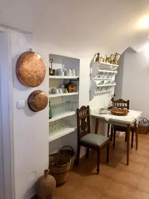 a dining room with a table and chairs and shelves at Constantia in Symi