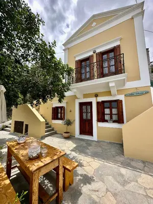 a house with a wooden table in front of it at Constantia in Symi