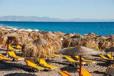 a bunch of chairs and umbrellas on a beach at STAY Rhodes Hotel in Rhodes Town