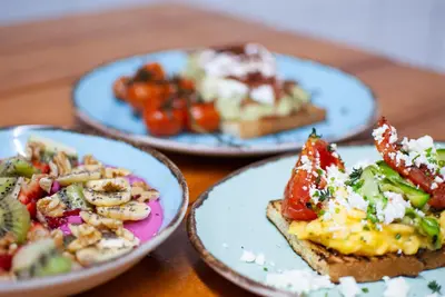 three plates of food on a wooden table at STAY Rhodes Hotel in Rhodes Town