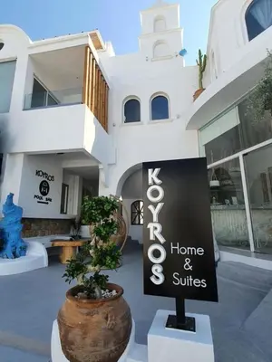 a home and suites sign in front of a building at Kouros Home & Suites in Faliraki