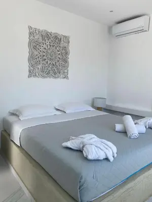 a bedroom with a bed with towels on it at Kouros Home & Suites in Faliraki