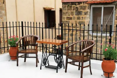 a table and two chairs and a table and a fence at Evangelia's Little House in Rhodes Town