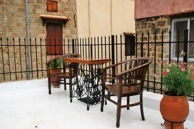a table and two chairs and a table and a fence at Evangelia's Little House in Rhodes Town