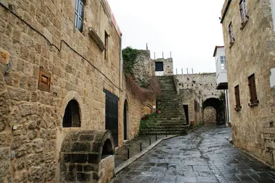 an alley in an old town with stone buildings at Evangelia's Little House in Rhodes Town