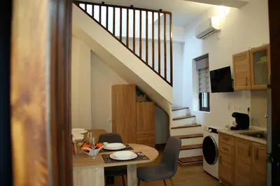 a kitchen and dining room with a table and a staircase at Evangelia's Little House in Rhodes Town