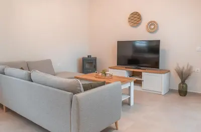 a living room with a couch and a table and a tv at Oliveto A Flumine - Experientia Villa in Pastida