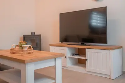 a living room with a flat screen tv and a table at Oliveto A Flumine - Experientia Villa in Pastida