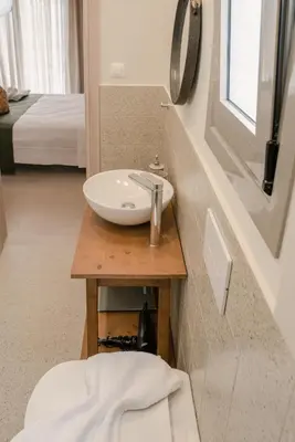 a bathroom with a sink and a bed at Oliveto A Flumine - Experientia Villa in Pastida
