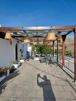 a shadow of a person taking a picture on a patio at Soultana studios in Líndos