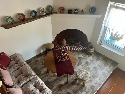a living room with a table and a fireplace at My sweet Greek dream - Traditional home in Soroni