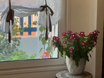 a vase with flowers on a table next to a window at My sweet Greek dream - Traditional home in Soroni