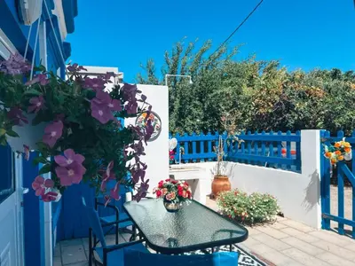 a patio with a table and flowers on a fence at My sweet Greek dream - Traditional home in Soroni