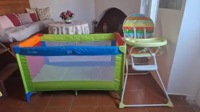 a colorful chair and a high chair next to a table at My sweet Greek dream - Traditional home in Soroni