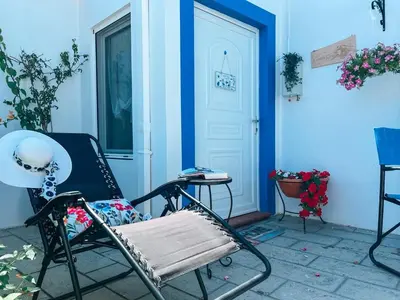a porch with a rocking chair and a door at My sweet Greek dream - Traditional home in Soroni