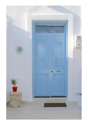 a blue door in a white wall with a potted plant at Kuspa House Soroni in Soroni