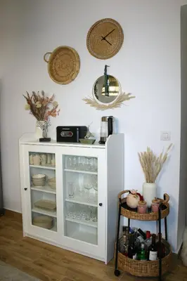 a white cabinet in a room with a clock on the wall at Kuspa House Soroni in Soroni