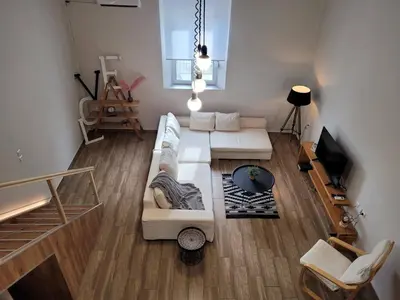 a living room with a white couch and a tv at KAZERMA ΗΟΜΕ in Rhodes Town