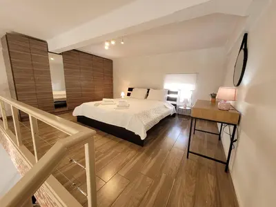 a large bedroom with a bed and a staircase at KAZERMA ΗΟΜΕ in Rhodes Town