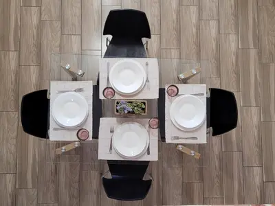 an overhead view of a table and chairs with white bowls at KAZERMA ΗΟΜΕ in Rhodes Town