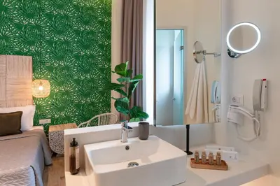 a bathroom with a sink and a bed and a mirror at Naillac Boutique Hotel in Rhodes Town