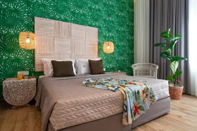 a bedroom with a large bed with a green wall at Naillac Boutique Hotel in Rhodes Town