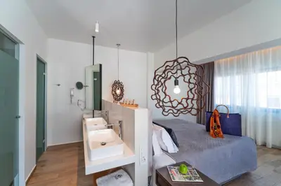 a bedroom with a bed with a sink and a mirror at Naillac Boutique Hotel in Rhodes Town