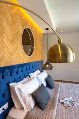 a bedroom with a bed with a blue headboard and a mirror at Naillac Boutique Hotel in Rhodes Town