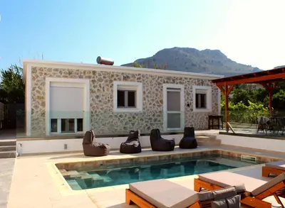 a villa with a swimming pool and a house at Casa Nikolou Stegna in Archangelos