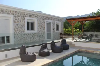a group of chairs sitting next to a swimming pool at Casa Nikolou Stegna in Archangelos