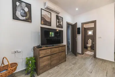 a living room with a flat screen tv on a wall at Casa Nikolou Stegna in Archangelos