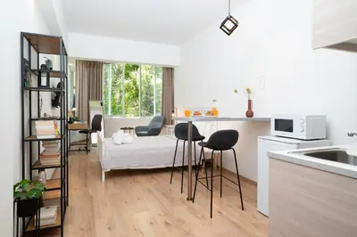 a kitchen with a bed and chairs in a room at Gravity Downtown Scandi Studio in Rhodes Town