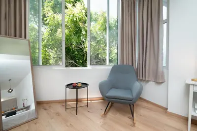 a living room with a blue chair and a table at Gravity Downtown Scandi Studio in Rhodes Town