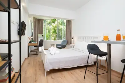 a bedroom with a white bed and two chairs at Gravity Downtown Scandi Studio in Rhodes Town