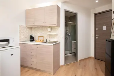 a kitchen with wooden cabinets and a sink and a refrigerator at Gravity Downtown Scandi Studio in Rhodes Town