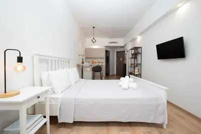 a white bedroom with a white bed and a desk at Gravity Downtown Scandi Studio in Rhodes Town