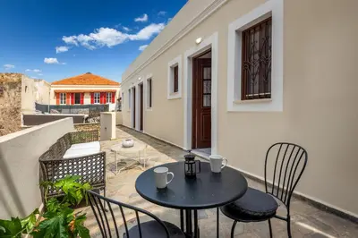 a patio with a table and chairs on a balcony at Cleomenes Old Town Studios in Rhodes Town