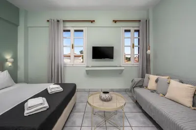 a living room with a couch and a tv at Cleomenes Old Town Studios in Rhodes Town