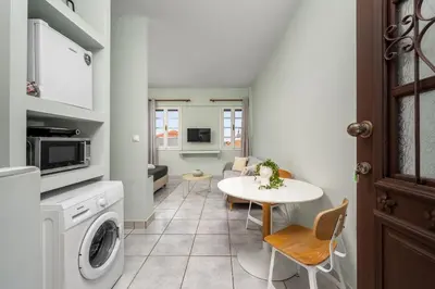 a kitchen with a table and a laundry room at Cleomenes Old Town Studios in Rhodes Town
