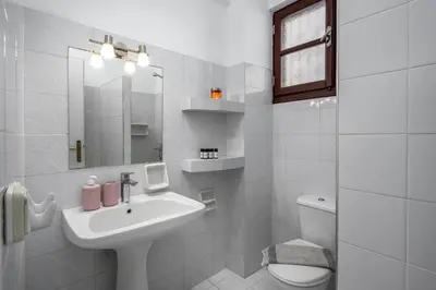 a white bathroom with a sink and a toilet at Cleomenes Old Town Studios in Rhodes Town
