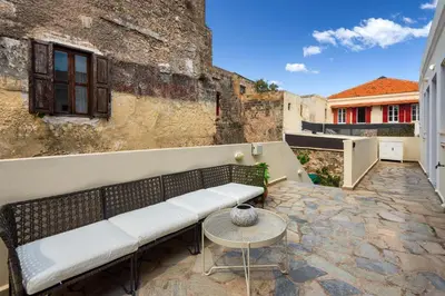 a couch sitting on a patio with a table at Cleomenes Old Town Studios in Rhodes Town