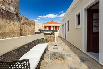 a patio with a white bench and a table at Cleomenes Old Town Studios in Rhodes Town