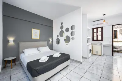 a bedroom with a large bed and a kitchen at Cleomenes Old Town Studios in Rhodes Town