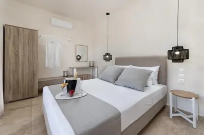 a bedroom with a large white bed with a tray on it at ANASTASIOS HOUSE STEGNA - UP FLOOR in Archangelos