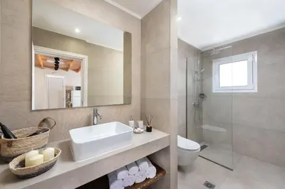 a bathroom with a sink and a toilet and a mirror at ANASTASIOS HOUSE STEGNA - UP FLOOR in Archangelos