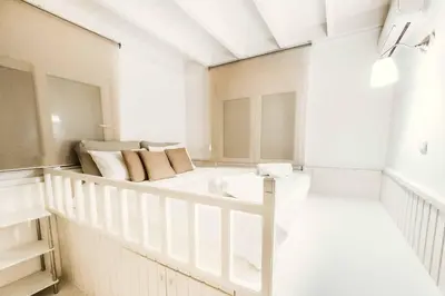 a white room with two beds in it at Ammos Beach House in Kiotari