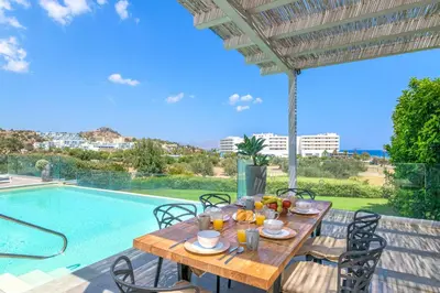 a wooden table with food on it next to a swimming pool at Villa Krini Delight in vlicha
