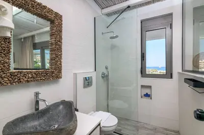 a bathroom with a sink and a toilet and a mirror at Villa Krini Delight in vlicha