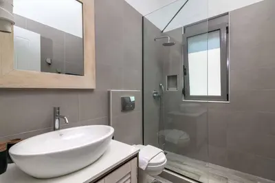 a bathroom with a white sink and a shower at Villa Krini Delight in vlicha