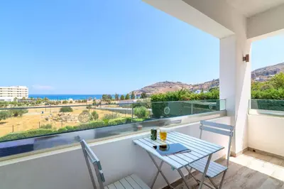 a table and chairs on a balcony with a view of the ocean at Villa Krini Myth in vlicha